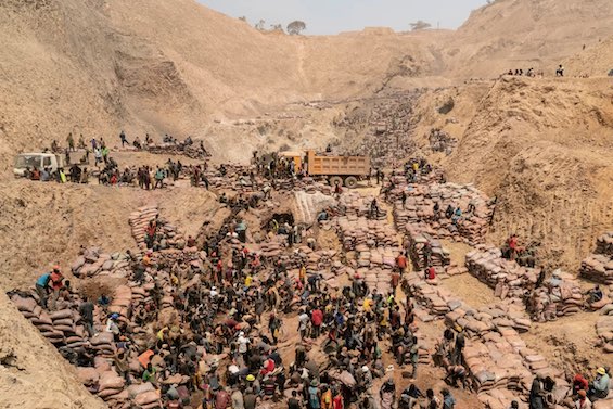 Photo of destitute miners in modern-day slavery scraping cobalt from the Earth in the DRC