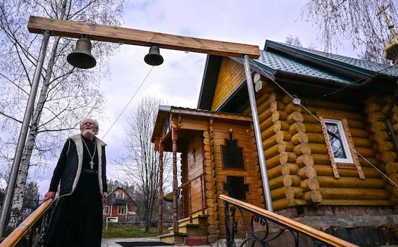 Photo of a Russian Orthodox village priest outside his church like the murdered priest in this Russian murder mystery
