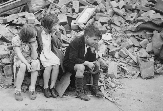 Photo of children sitting on rubble in London after World War II, a sight common shortly before this standalone historical thriller opens