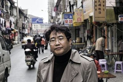 Photo of Qiu Xiaolong on a Chinese city street, author of this novel about China in transition
